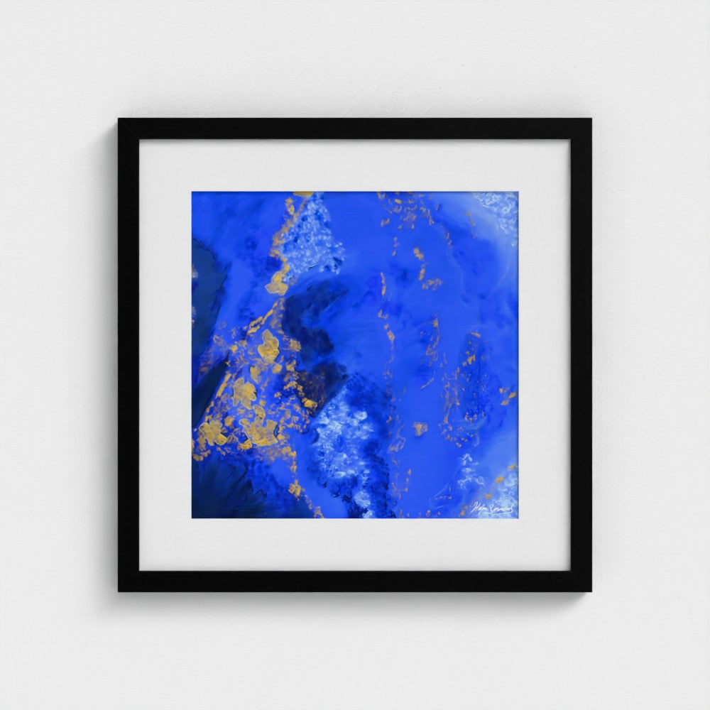 A blue abstract paper wall art print in a black frame styled on a light wall