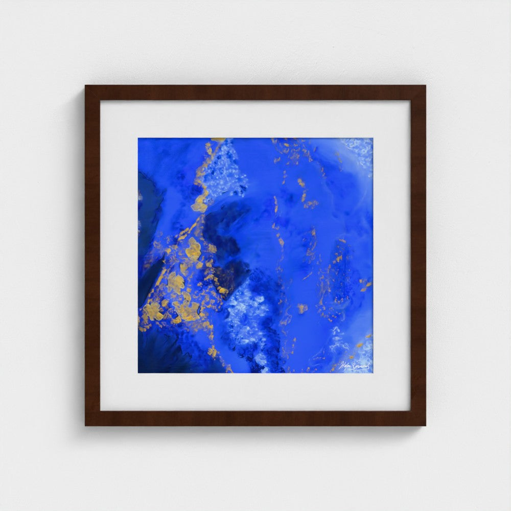 A blue abstract paper wall art print in a dark brown frame styled on a light wall