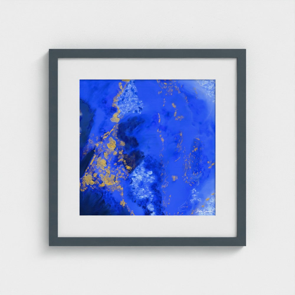 A blue abstract paper wall art print in a dark grey frame styled on a light wall