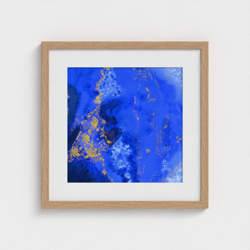 A blue abstract paper wall art print in a natural frame styled on a light wall