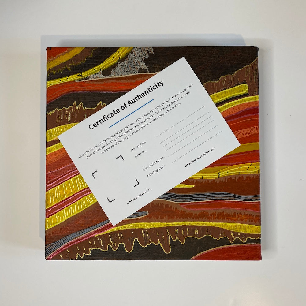 a certificate of authenticity on top of an abstract canvas