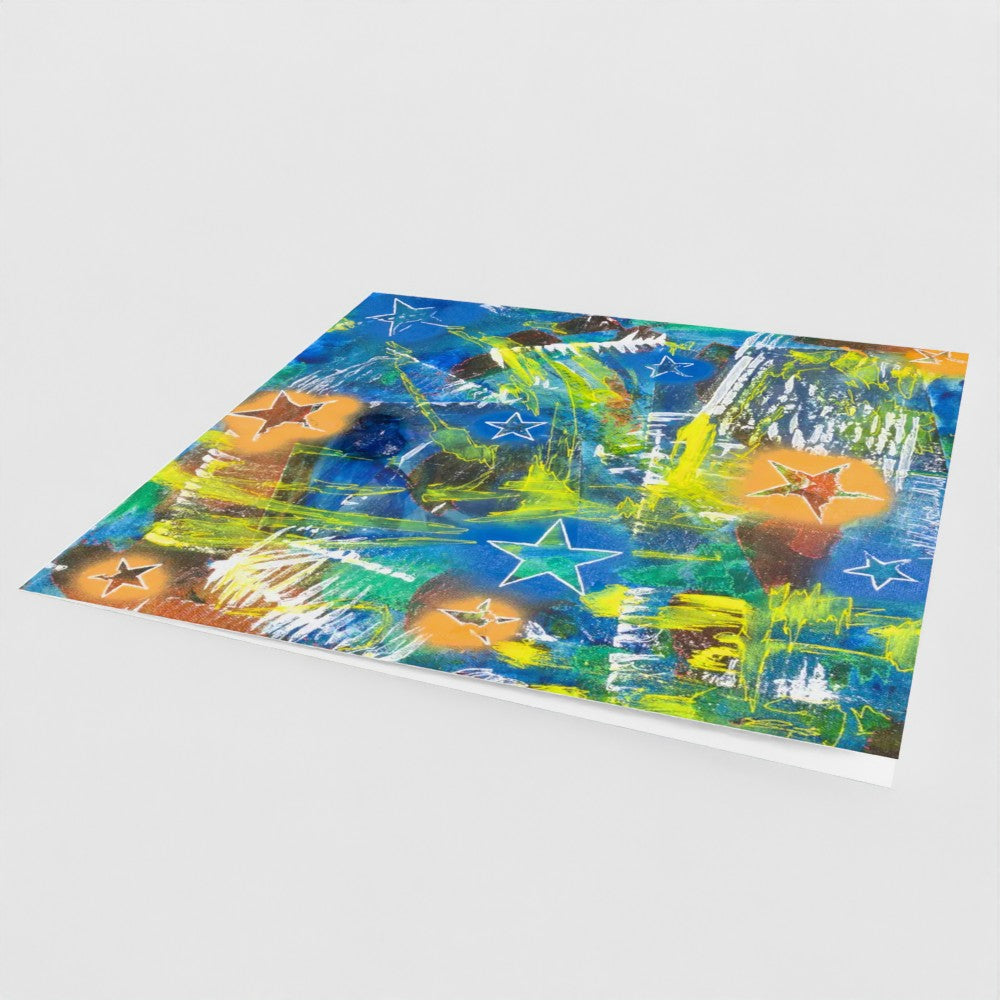the front cover, at an angle, of a square greeting card in a multi-coloured abstract design