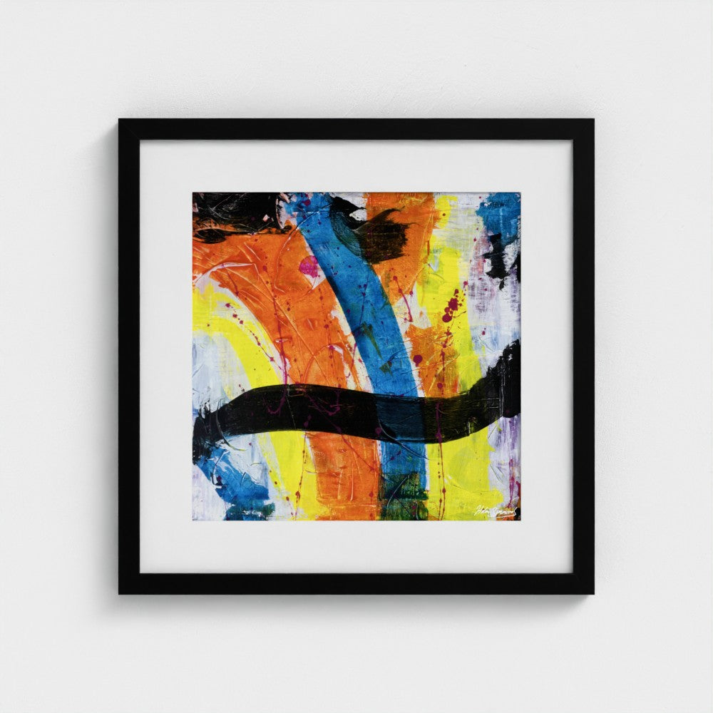 A colourful paper art print in a black frame styled on a light wall