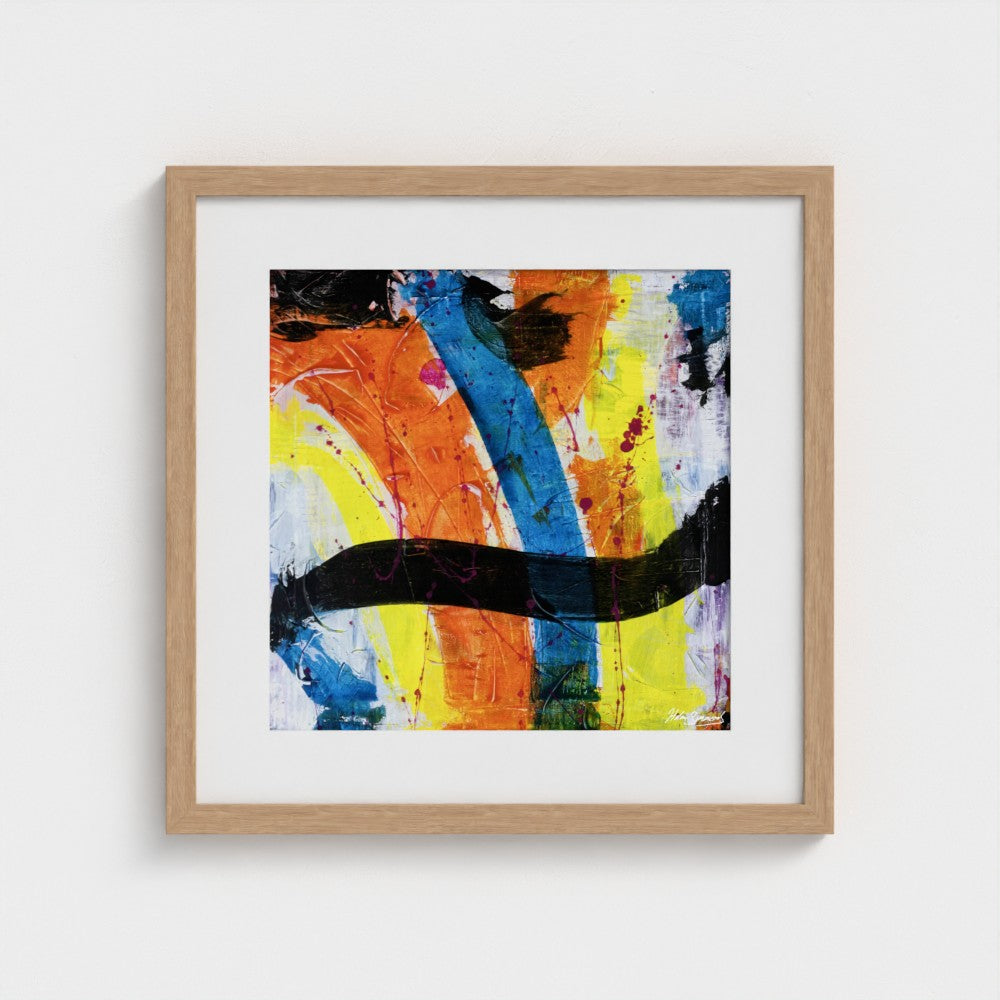 A colourful paper art print in a natural frame styled on a light wall
