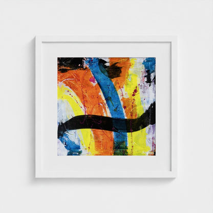 A colourful paper art print in a white frame styled on a light wall