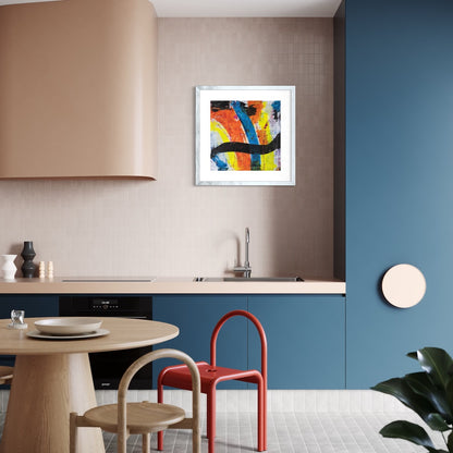 A colourful paper art print in an antique silver frame styled on a light wall in a kitchen with blue cupboards.
