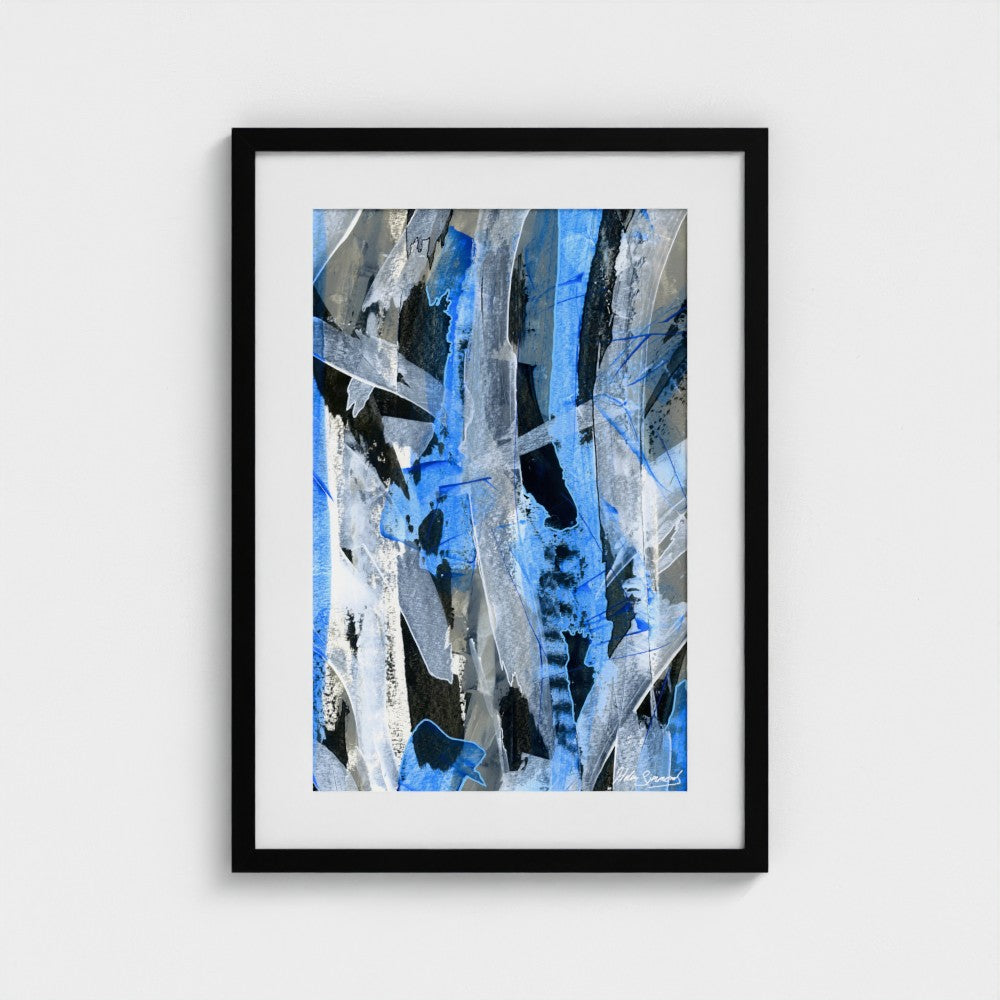 A blue abstract paper art print in a black frame styled on a light wall