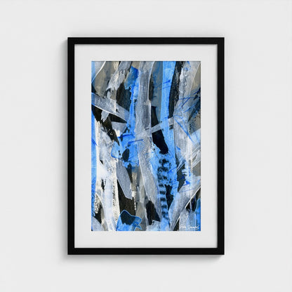 A blue abstract paper art print in a black frame styled on a light wall