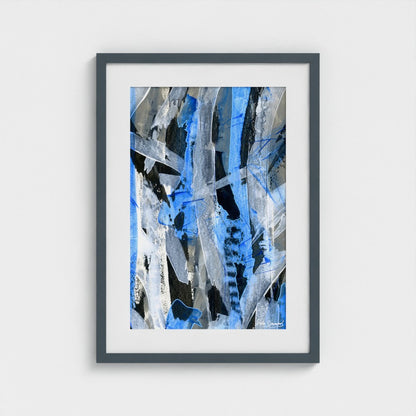 A blue abstract paper art print in a dark grey frame styled on a light wall