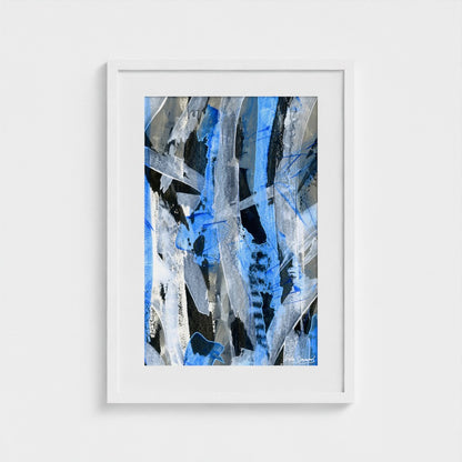 A blue abstract paper art print in a white frame styled on a light wall