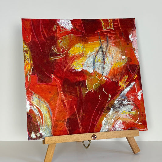 red abstract limited edition paper print on a wooden stand with a white backdrop