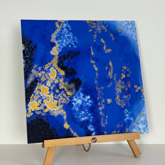 blue abstract limited edition paper print on a wooden stand with a white backdrop