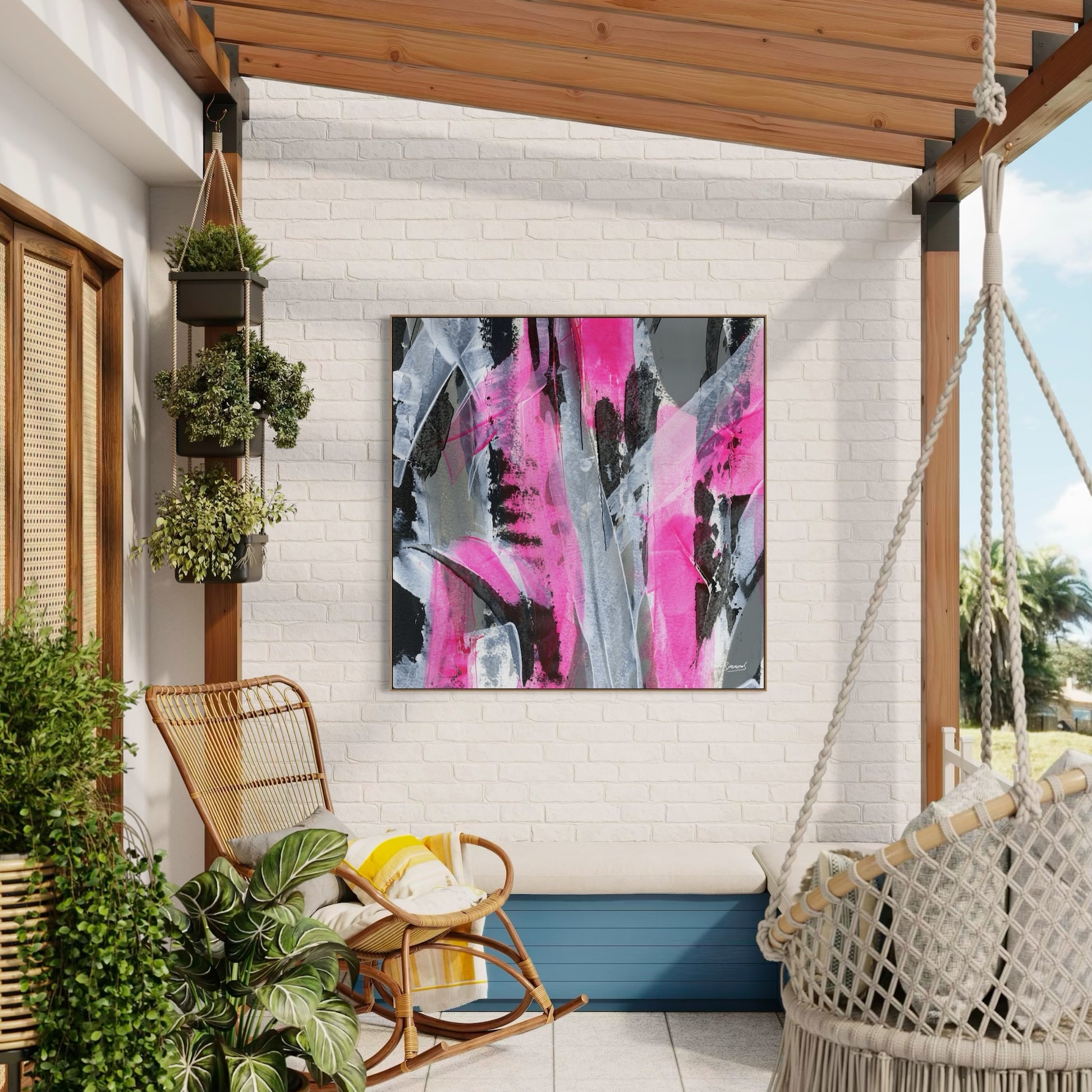 Square natural framed pink abstract canvas wall art print on a white wash wall outdoor space with a pergola